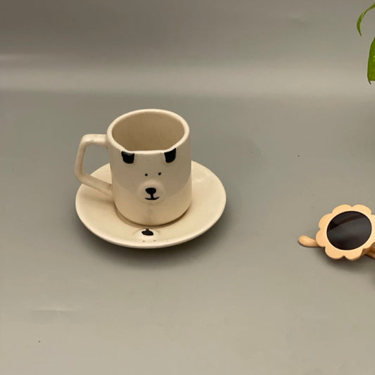 Small ceramic milk mug with dog face and matching dog face saucer