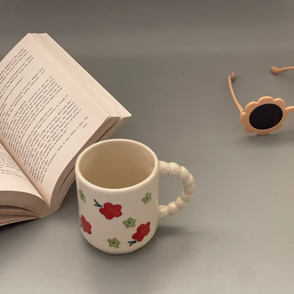 Ceramic milk mug with red flower prints and delicately carved handle