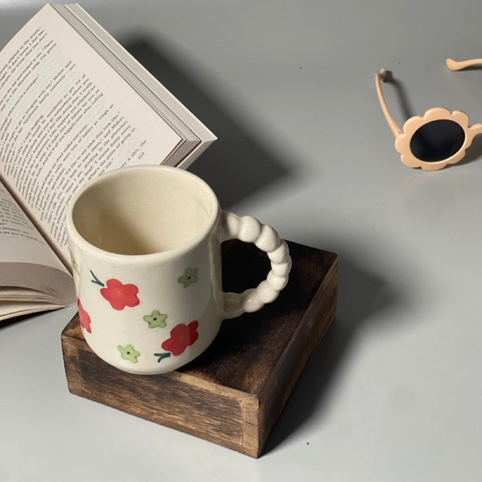 Ceramic milk mug with red flower prints and delicately carved handle