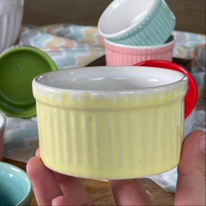 Collection of colorful ceramic ramekins on a table with a blurred background
