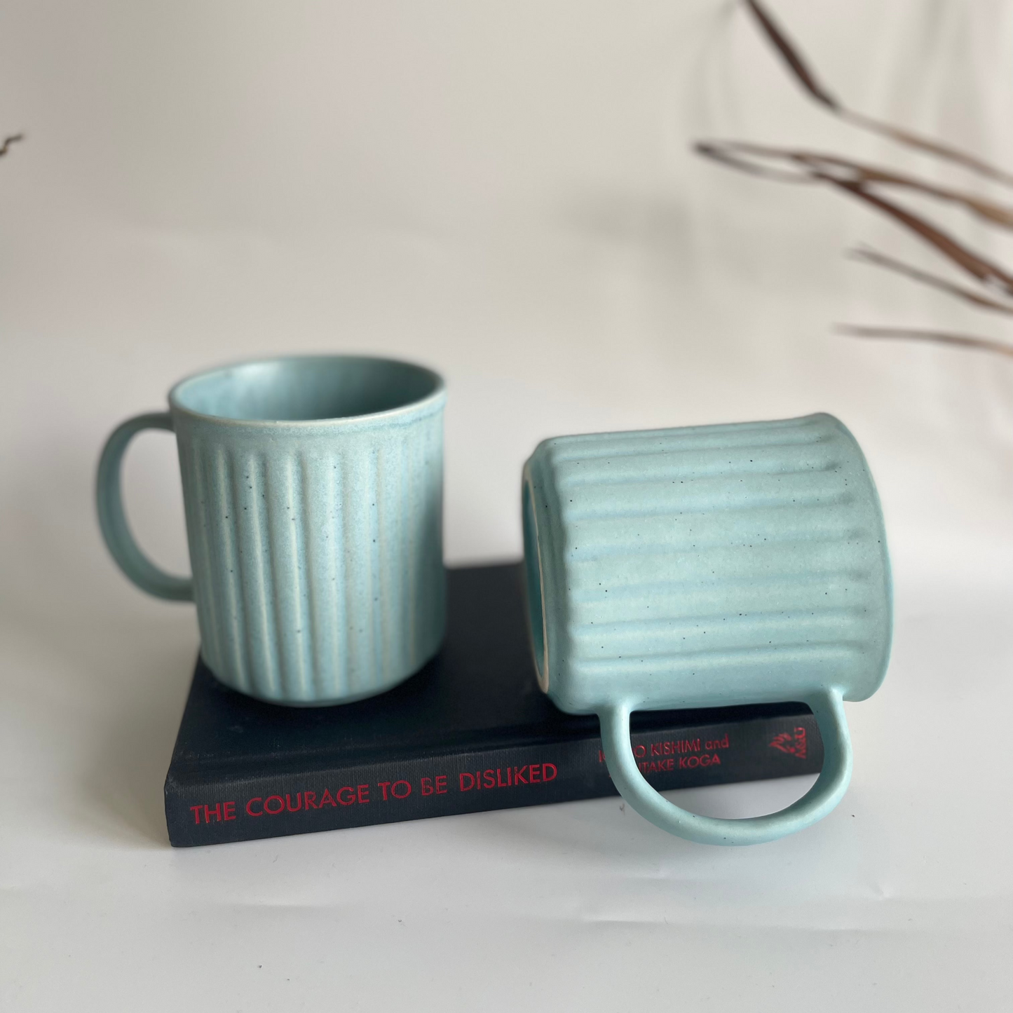 Ceramic ribbed mugs available in pastel purple, pastel blue, and earthy brown