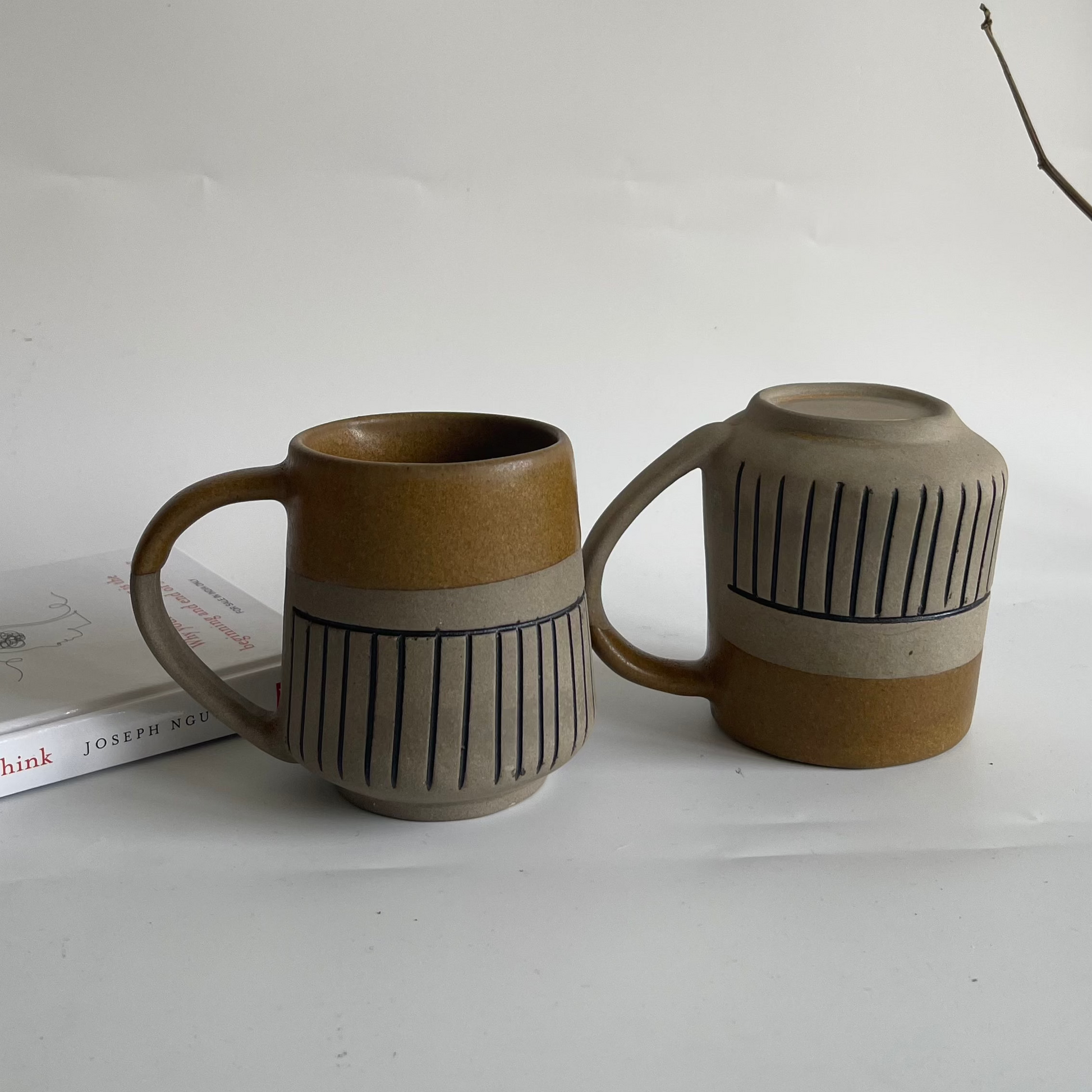 Rustic ceramic mug with glyph design and half brown glaze finish