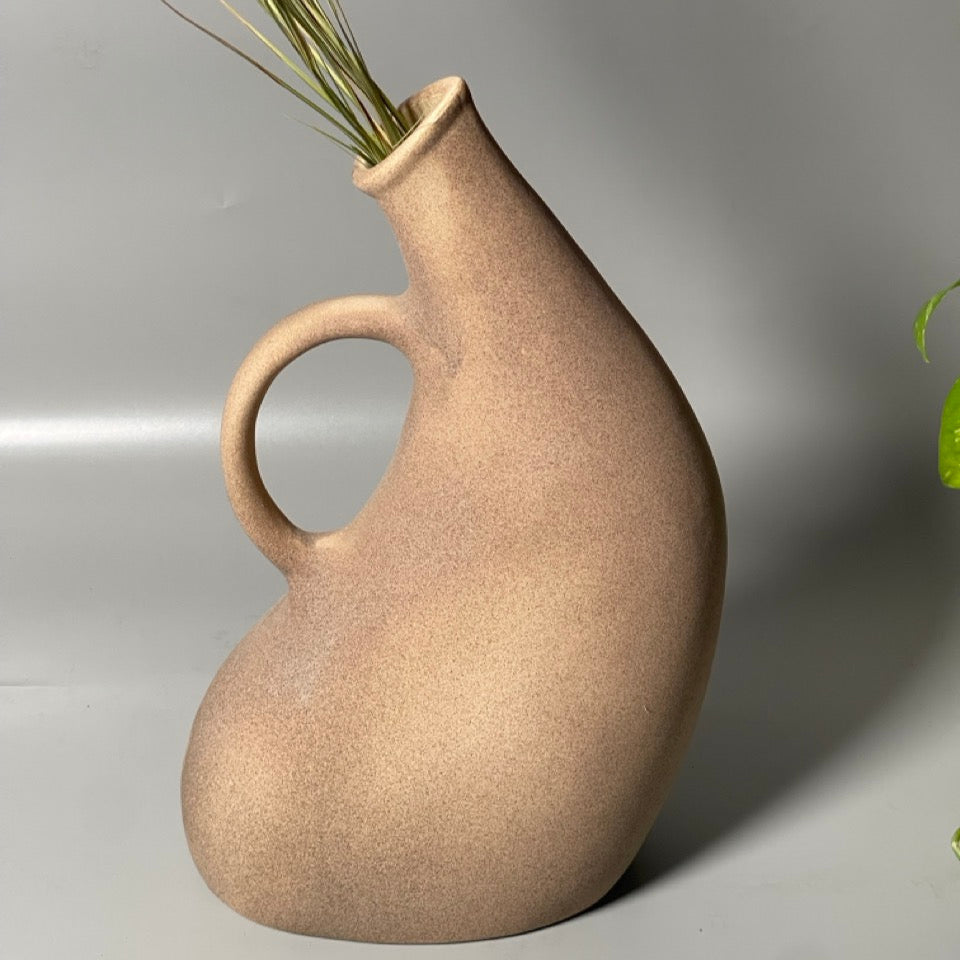 Brown ceramic jug vase with curved handle and spout in a hand-pipe inspired design