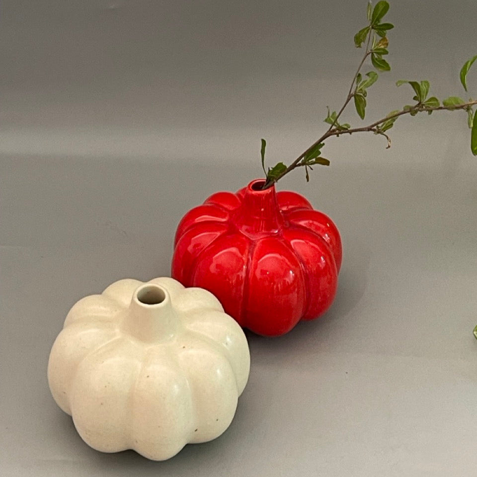 White ceramic vase in pumpkin shape with vertical ridges and glossy finish