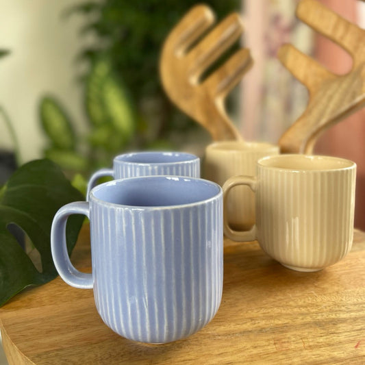 Set of ceramic mugs on a wooden surface with a blurred background