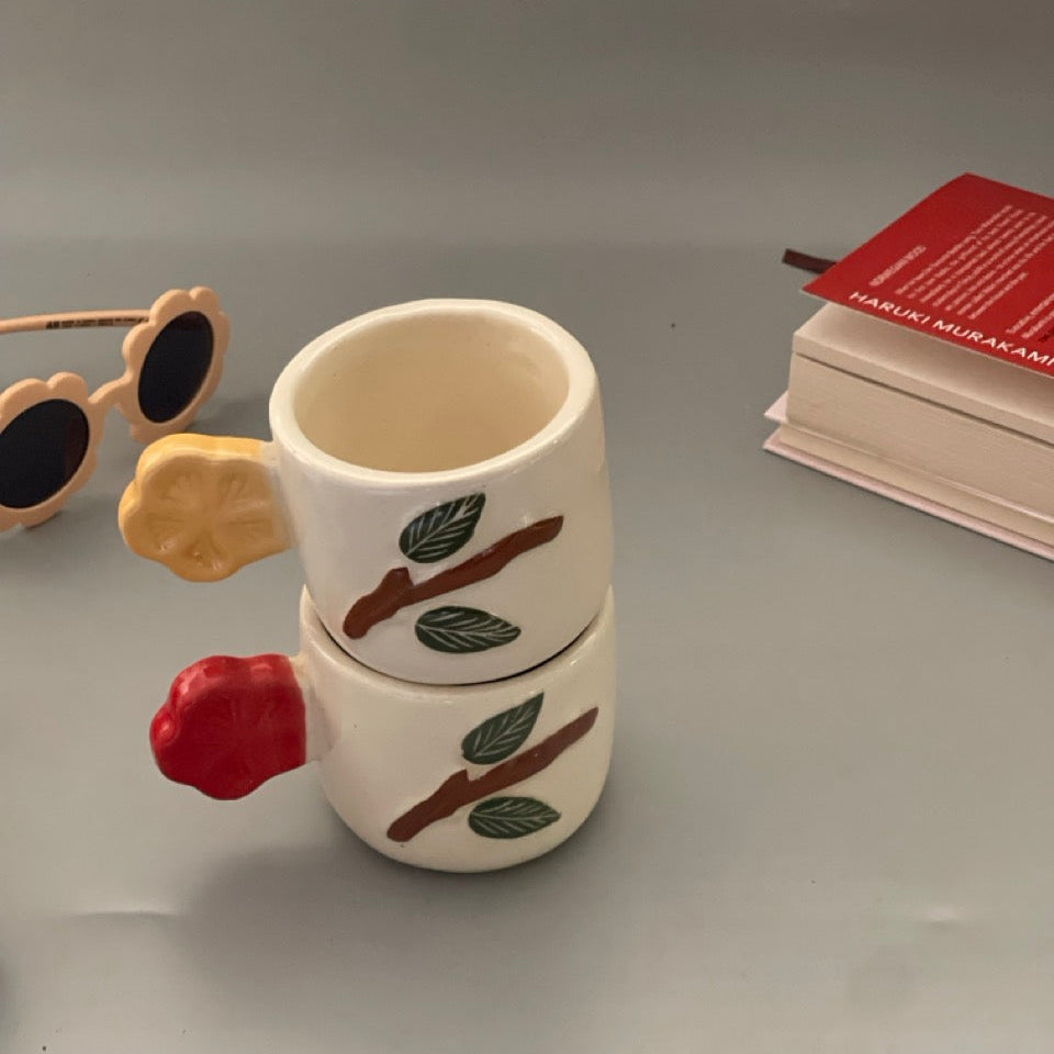 Set of 2 ceramic cups with birdtail-shaped handles and branch motifs in yellow and red