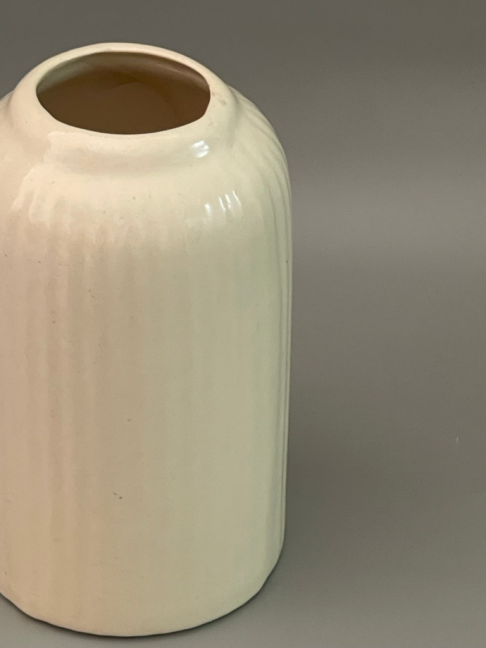 Glossy white ceramic vase with ribbed texture stout silhouette