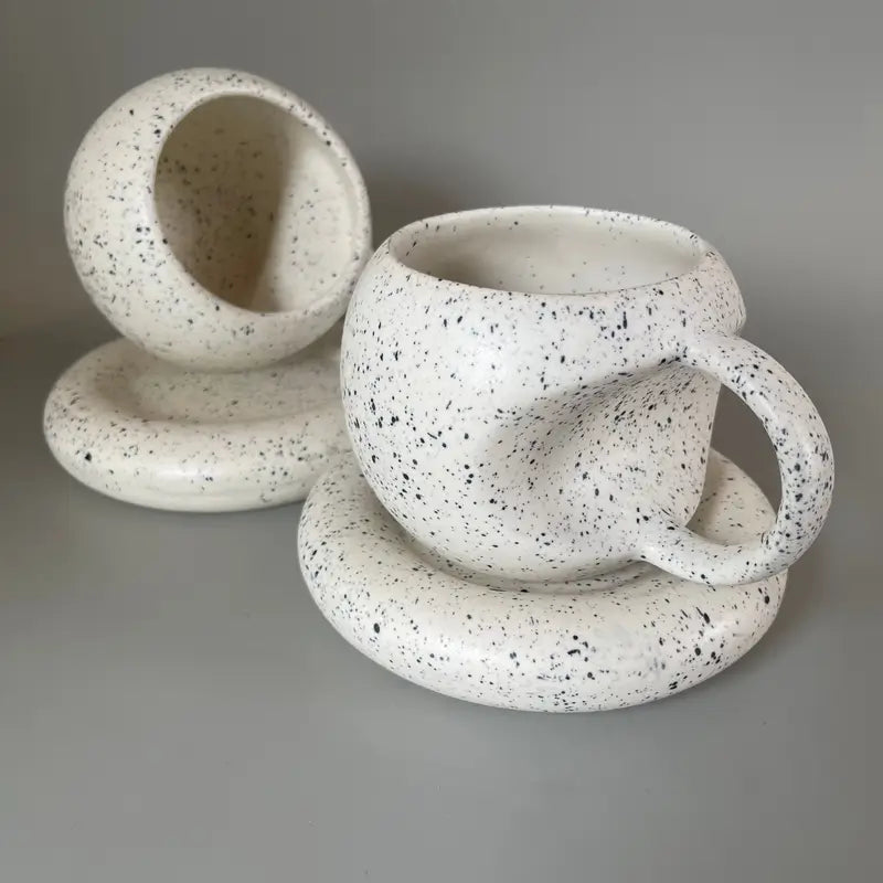 Speckled Apple ceramic mug and saucer set on a gray background