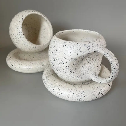 Speckled Apple ceramic mug and saucer set on a gray background