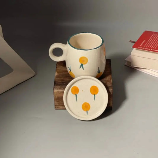 Berry print Ceramic mug and coaster set with floral design on a wooden block against a neutral background.