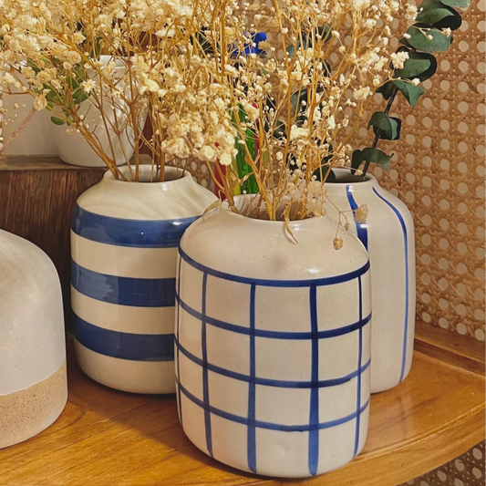Decorative arrangement ofBlue Tinea Trio  vases with dried plants on a wooden shelf.