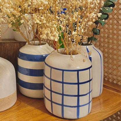 Set of Blue Linea ceramic vases with blue accents on a wooden surface.
