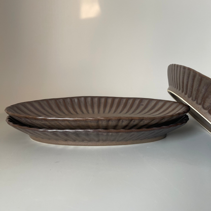 Brown oval ceramic platter with ribbed texture, ideal for serving appetisers or festive snacks