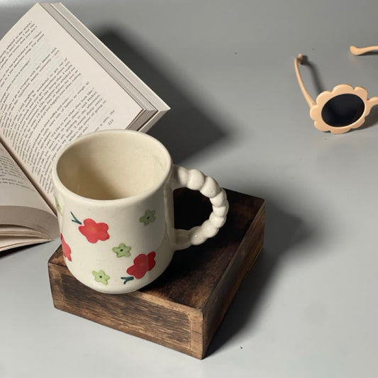 Ceramic milk mug with red flower prints and delicately carved handle