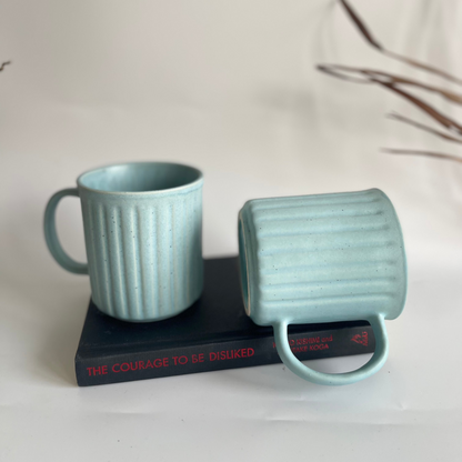Ceramic ribbed mugs available in pastel purple, pastel blue, and earthy brown