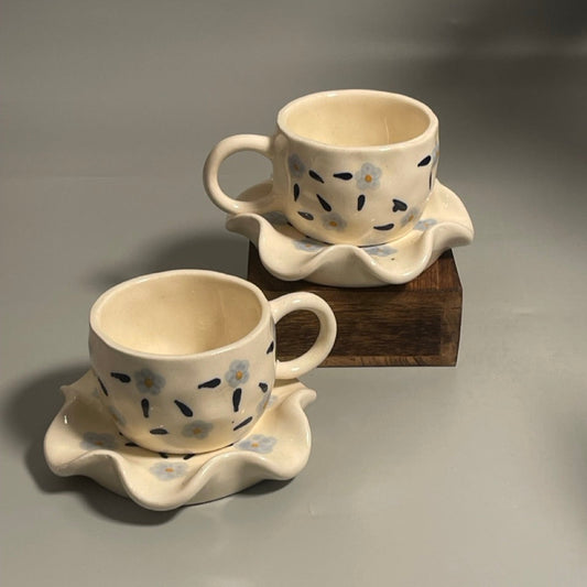 Floral ceramic cup with purple flower motifs and flower-shaped saucer
