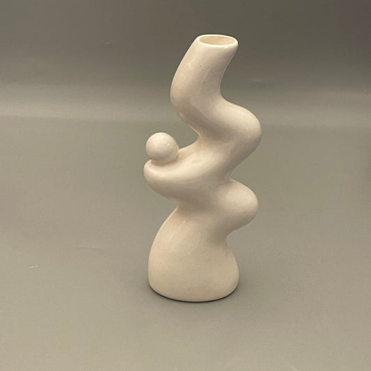 Glossy white ceramic vase styled as a bookend with minimal design