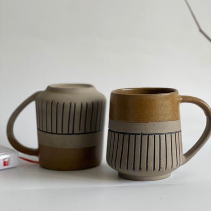 Rustic ceramic mug with glyph design and half brown glaze finish