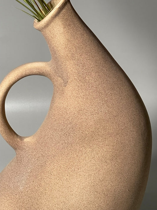 Brown ceramic jug vase with curved handle and spout in a hand-pipe inspired design