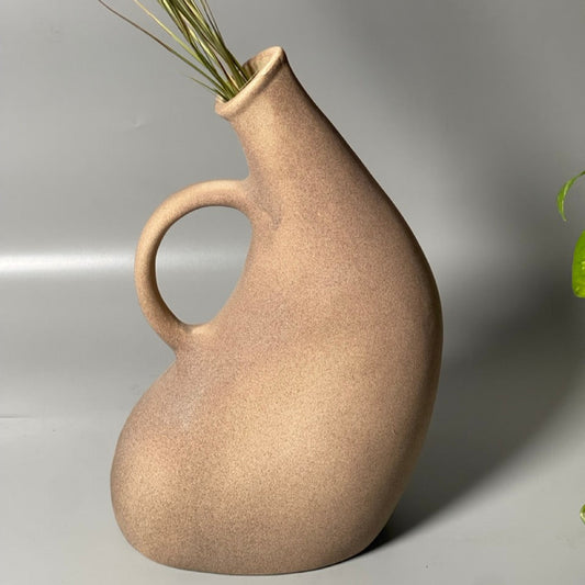 Brown ceramic jug vase with curved handle and spout in a hand-pipe inspired design
