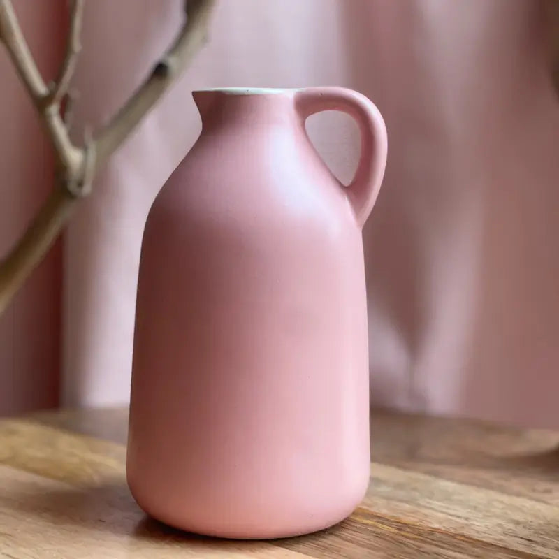 Pink Jugscapes ceramic vase on a wooden surface with a blurred background