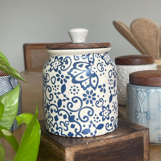 Ceramic jar with blue floral patterns on a wooden surface
