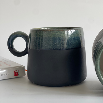 Large ceramic mugs with round orbit handle, available in green-black and white with dotted colors

