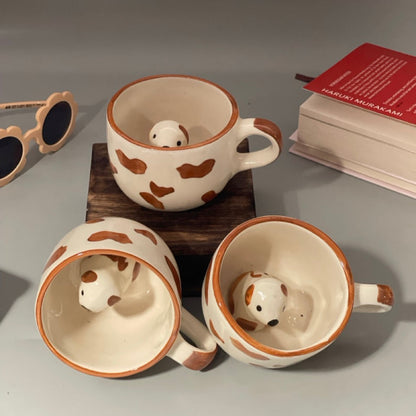 Glossy ceramic mug with paw prints and hidden dog figurine inside