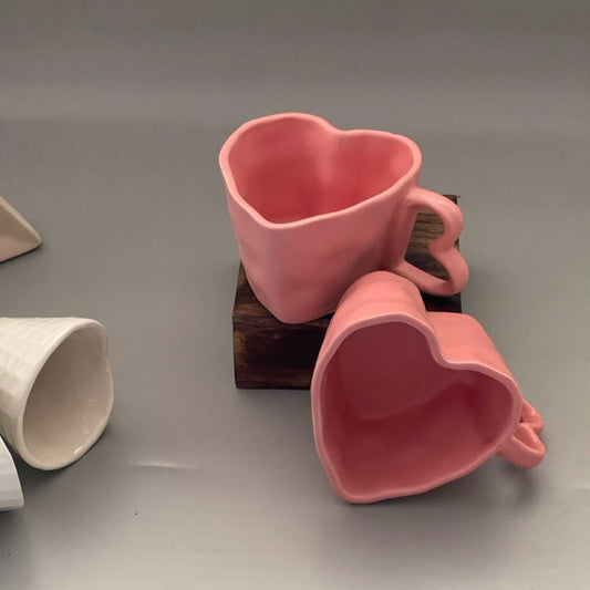 Set of two pink ceramic heart-shaped mugs with matching heart handles, perfect for couples or gifting