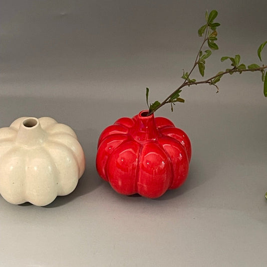 White ceramic vase in pumpkin shape with vertical ridges and glossy finish