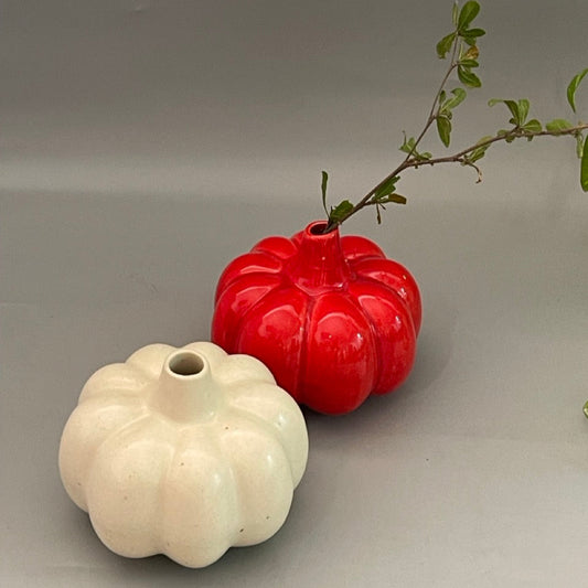 White ceramic vase in pumpkin shape with vertical ridges and glossy finish