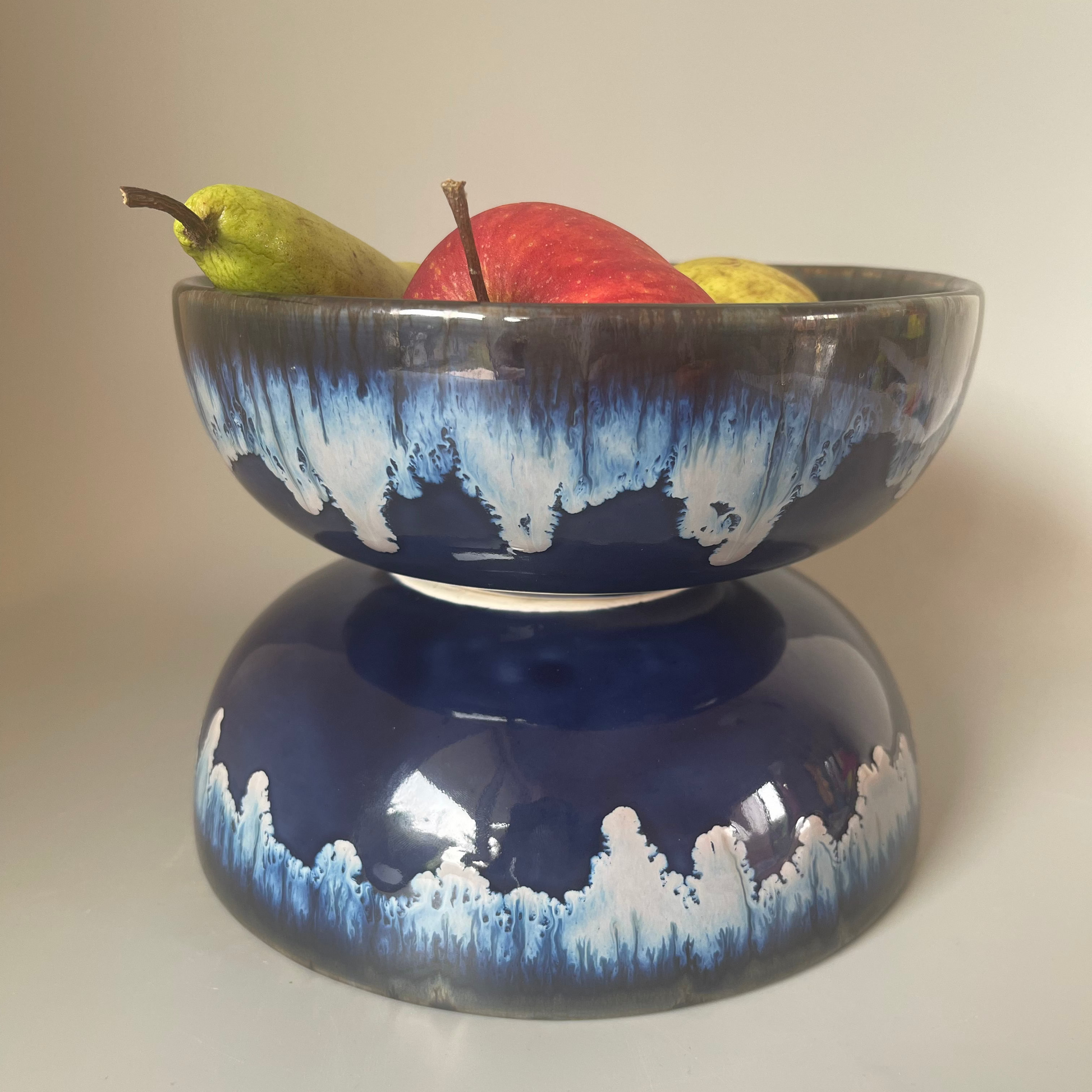 7 inch ceramic Seasque serve bowl with blue interior and white dripping glaze exterior, inspired by ocean waves