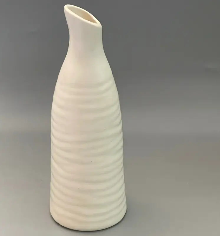 White Spoutform ceramic vase with ribbed texture on a gray background