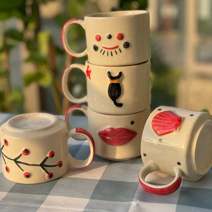 Stack of ceramic mugs with facial features on a checkered tablecloth