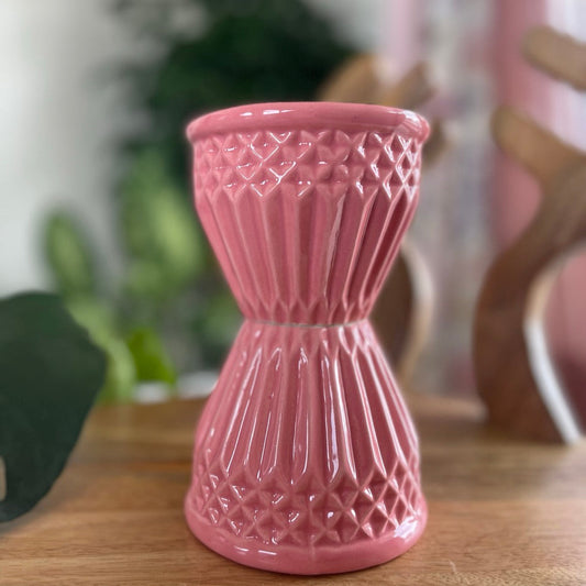 Pink textured soup bowl on a wooden surface with a blurred background