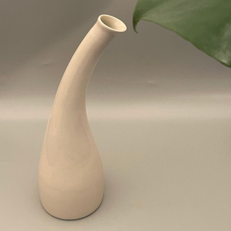 Tall ceramic vase with narrow neck and wide base in solid color finish