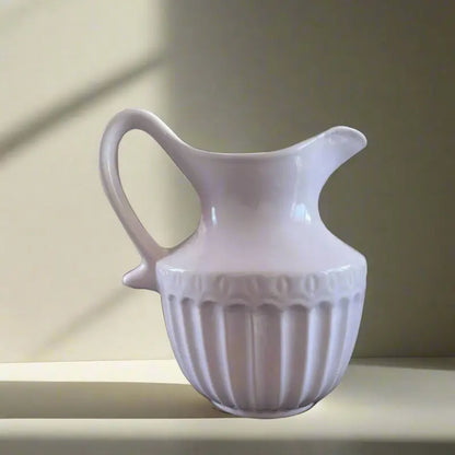 White Victorian ceramic pitcher Jug with decorative design on a neutral background