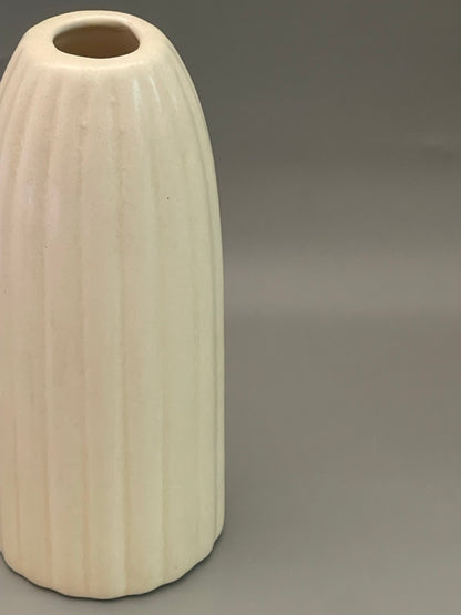Closeup of Glossy white ceramic vase with ribbed texture, tall 
