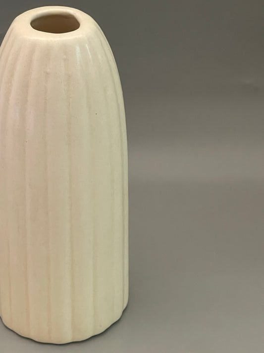 Closeup of Glossy white ceramic vase with ribbed texture, tall 